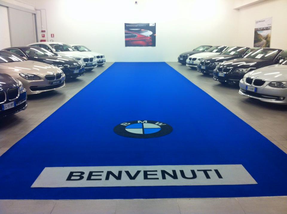 Passatoia blu BMW con scritta Benvenuti in showroom auto