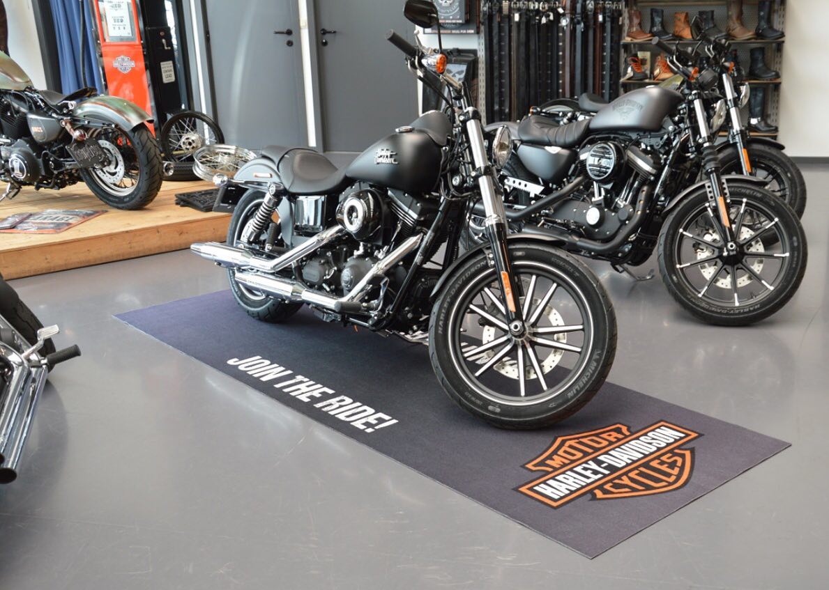 Tappeto grigio con logo Harley-Davidson e scritta Join the Ride in showroom